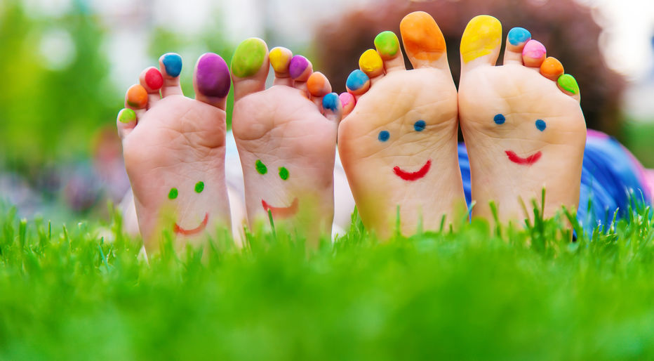 Children's feet with smiling paint and painted toes, representing happy feet